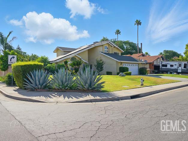 3717 Alcott Dr, Bakersfield, CA 93311 - view of front facade featuring a garage, driveway, a front yard, and stucco siding