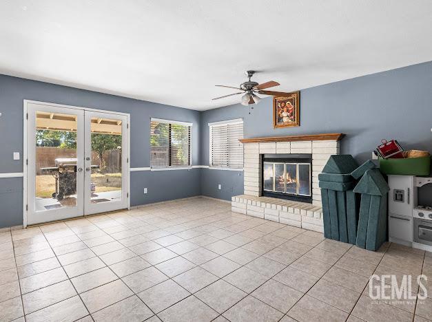 3717 Alcott Dr, Bakersfield, CA 93311 - unfurnished living room with a ceiling fan, a brick fireplace, tile patterned floors, and french doors