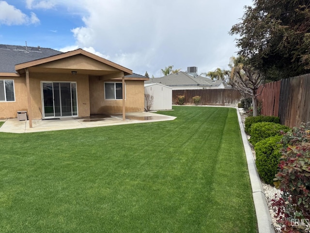 view of yard featuring a shed, central air condition unit, a fenced backyard, a patio area, and an outbuilding