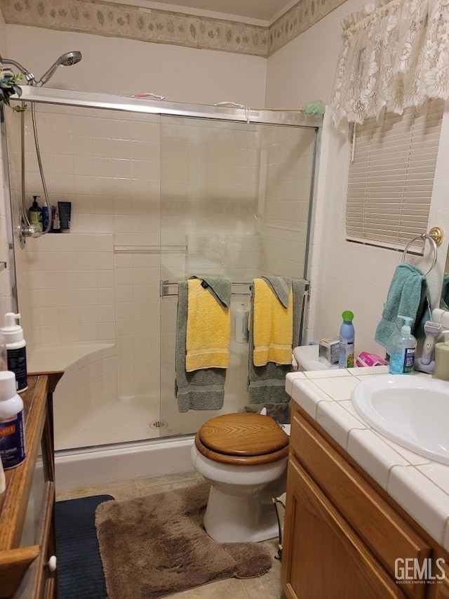 bathroom featuring vanity, toilet, a stall shower, and tile patterned flooring