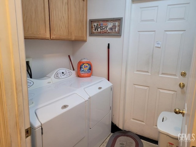 clothes washing area with washer and clothes dryer and cabinet space