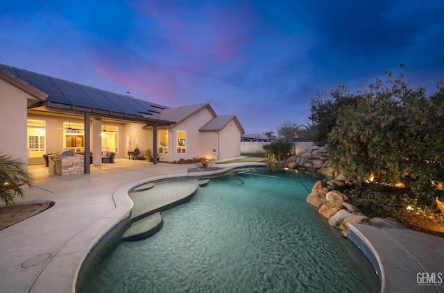 pool at dusk featuring a patio area