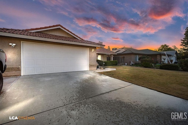 view of front of property with a garage and a yard