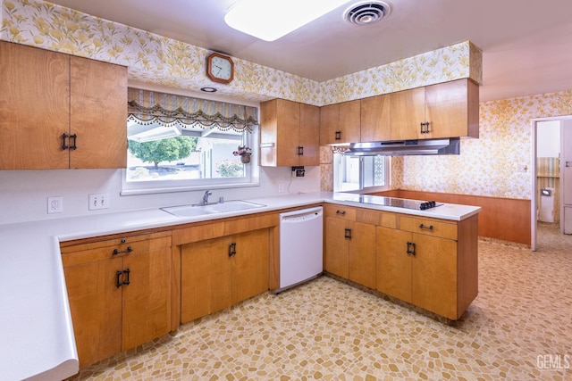 1830 Chevy Chase Way, Bakersfield, CA 93306 - kitchen with wallpapered walls, white dishwasher, under cabinet range hood, light countertops, and brown cabinetry