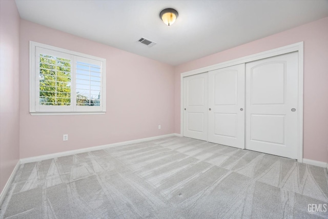 unfurnished bedroom with carpet floors, a closet, visible vents, and baseboards