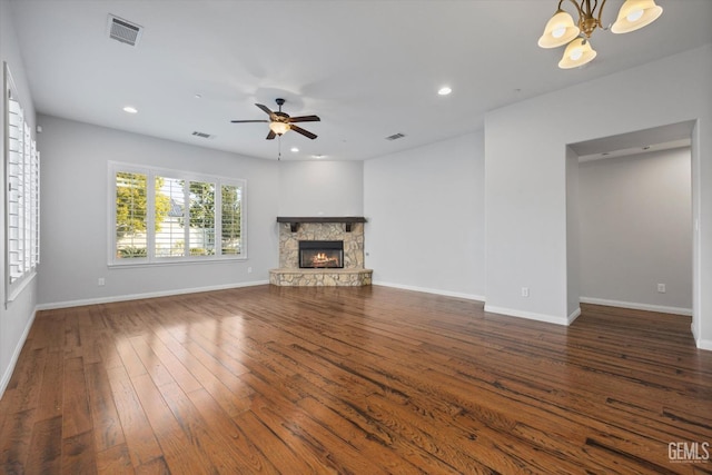 unfurnished living room with baseboards, visible vents, dark wood finished floors, a fireplace, and recessed lighting