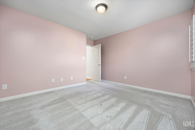 empty room with carpet and baseboards