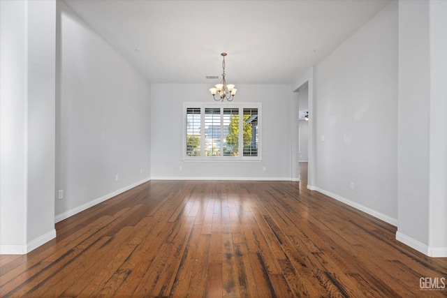 unfurnished room with baseboards, dark wood-type flooring, visible vents, and an inviting chandelier