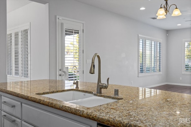 kitchen with stone countertops, a wealth of natural light, a sink, and recessed lighting