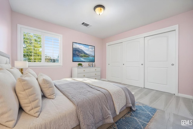 bedroom with a closet, visible vents, and baseboards