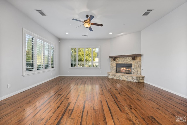 unfurnished living room featuring baseboards, visible vents, a fireplace, and hardwood / wood-style floors