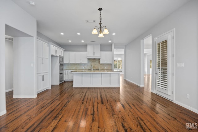 kitchen with tasteful backsplash, visible vents, an inviting chandelier, dark wood-type flooring, and white cabinets