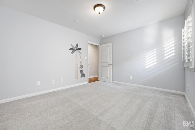 carpeted empty room featuring baseboards