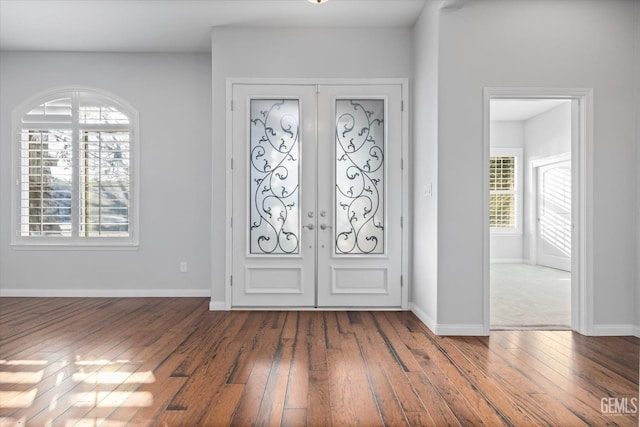 foyer featuring hardwood / wood-style flooring, baseboards, and french doors