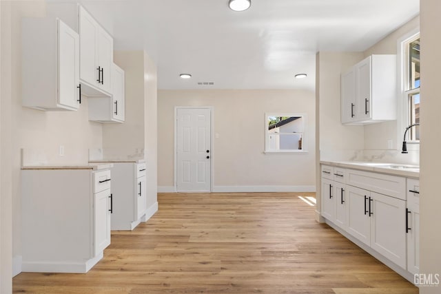 702 Wilson Ave, Bakersfield, CA 93308 - kitchen featuring light wood-style flooring, light countertops, white cabinets, and recessed lighting