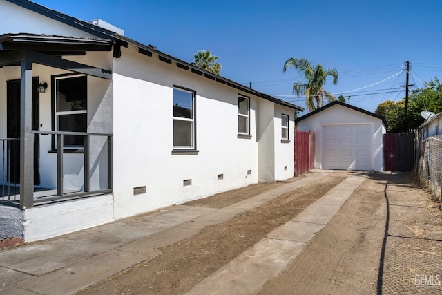 702 Wilson Ave, Bakersfield, CA 93308 - view of side of property with crawl space, concrete driveway, an outdoor structure, a detached garage, and stucco siding