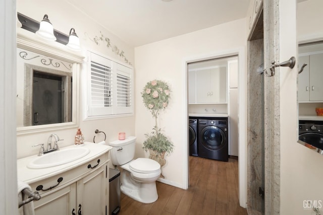 bathroom featuring vanity, toilet, wood finished floors, and washing machine and clothes dryer