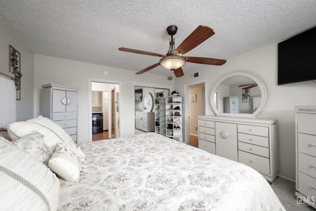 bedroom featuring visible vents, a ceiling fan, washer / clothes dryer, a textured ceiling, and carpet floors