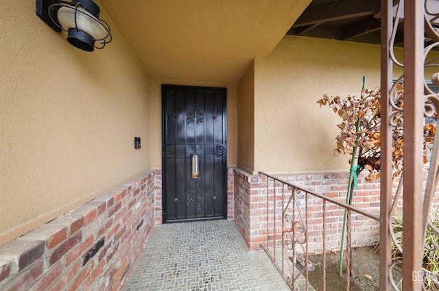 entrance to property featuring stucco siding