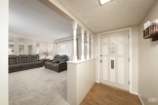 foyer featuring baseboards, a textured ceiling, and wood finished floors