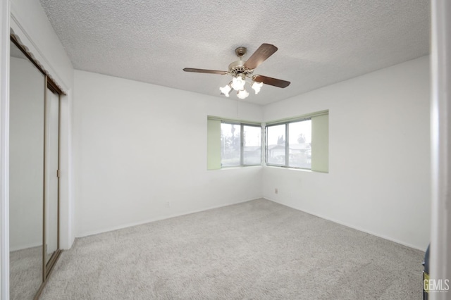 unfurnished bedroom with a closet, carpet flooring, a textured ceiling, and a ceiling fan