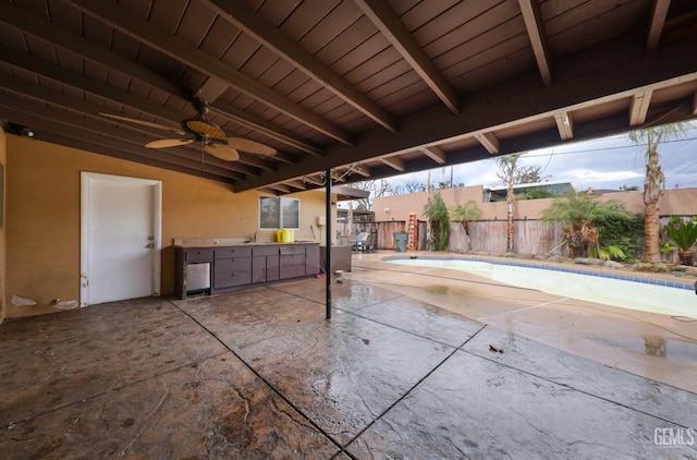 view of patio / terrace with a fenced in pool, exterior kitchen, ceiling fan, and fence