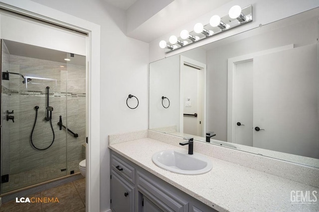 bathroom with an enclosed shower, vanity, tile patterned flooring, and toilet