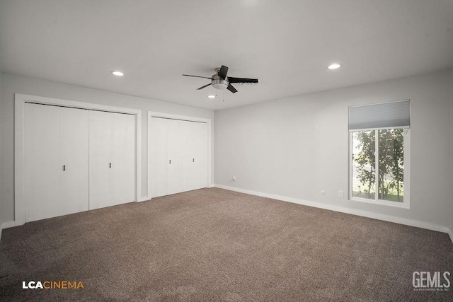 unfurnished bedroom with ceiling fan, two closets, and carpet floors