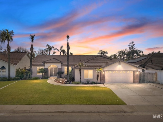 view of front of property with a yard and a garage