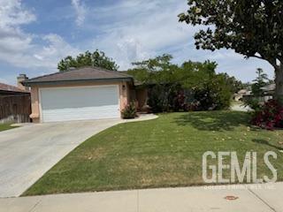 ranch-style home with driveway, an attached garage, and a front yard