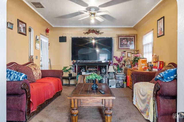 living room with visible vents, carpet floors, and ceiling fan