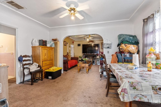 carpeted dining area featuring arched walkways, visible vents, and a ceiling fan