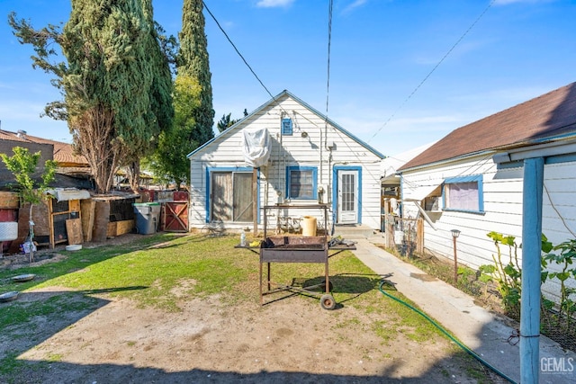 rear view of house with a lawn and fence