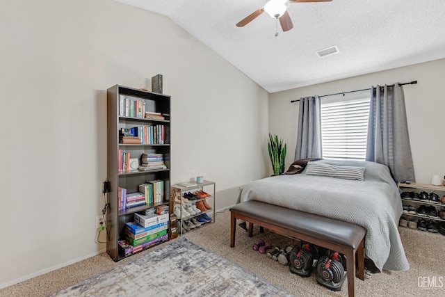 carpeted bedroom featuring a textured ceiling, vaulted ceiling, and ceiling fan