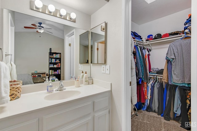 bathroom with ceiling fan, vanity, and lofted ceiling