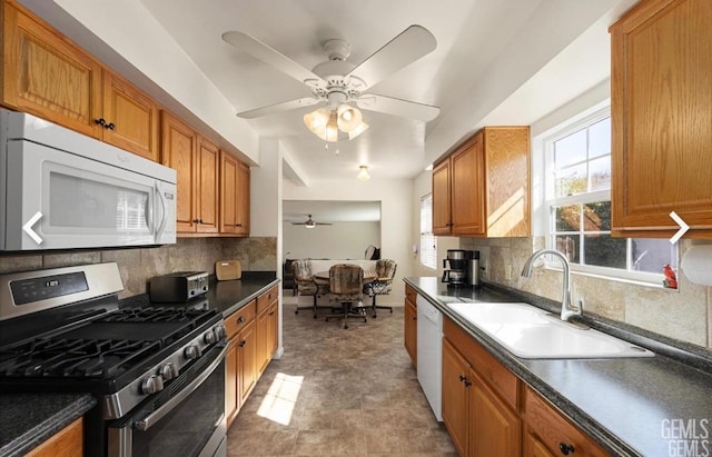 kitchen featuring white appliances, tasteful backsplash, sink, and ceiling fan