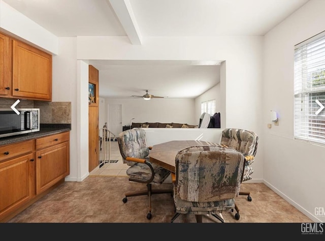 dining area featuring ceiling fan, beamed ceiling, and light tile patterned floors