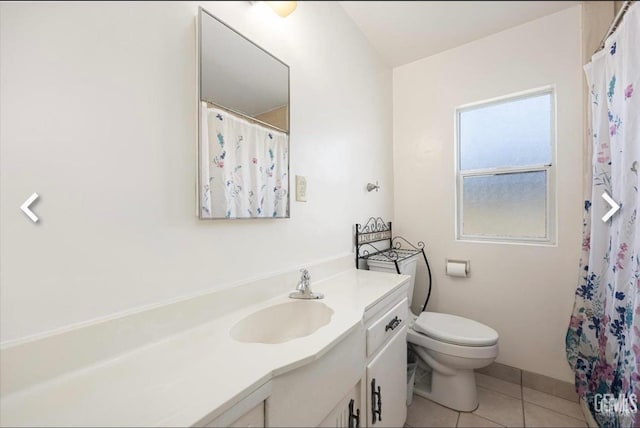 bathroom featuring toilet, vanity, tile patterned floors, and a shower with curtain