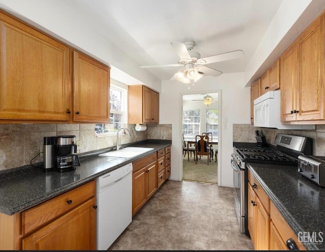 kitchen featuring white appliances, tasteful backsplash, sink, and ceiling fan