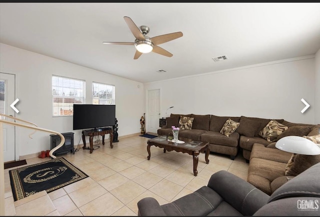 tiled living room featuring ceiling fan and ornamental molding