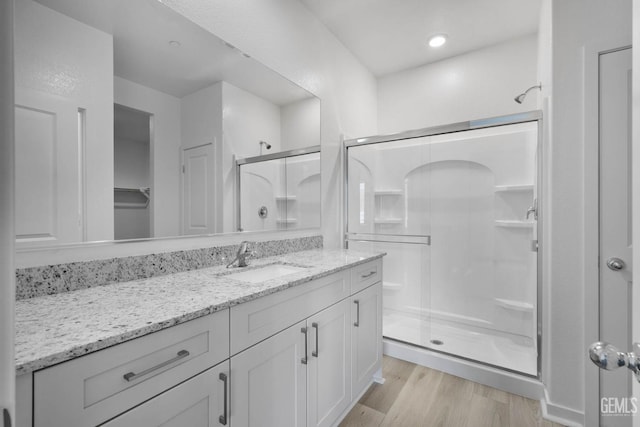 5016 Beaverhead Ave, Bakersfield, CA 93306 - bathroom with a stall shower, vanity, wood finished floors, and a closet
