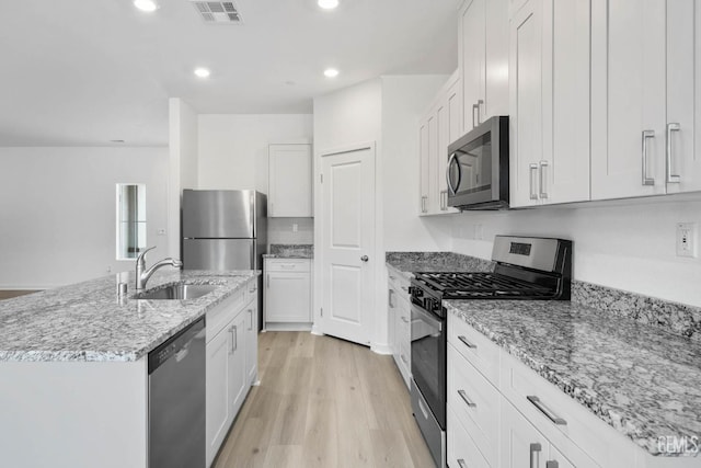 5016 Beaverhead Ave, Bakersfield, CA 93306 - kitchen with stainless steel appliances, light wood-type flooring, light stone counters, a center island with sink, and recessed lighting