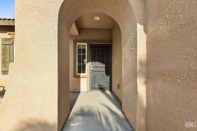 view of exterior entry with stucco siding