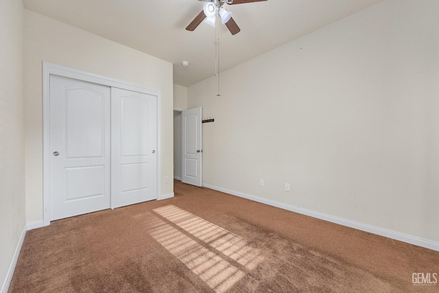 unfurnished bedroom with carpet flooring, a ceiling fan, baseboards, and a closet