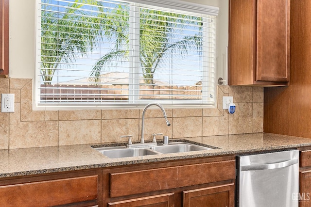 kitchen featuring a sink, backsplash, dishwasher, and brown cabinets