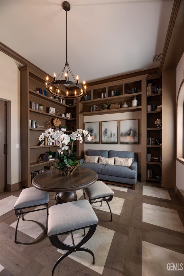 dining space featuring light parquet floors, crown molding, built in features, and a chandelier