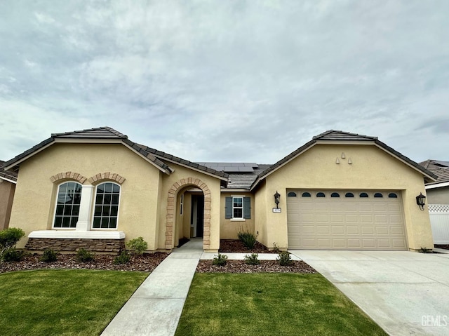 view of front of home featuring a garage, a front yard, and solar panels