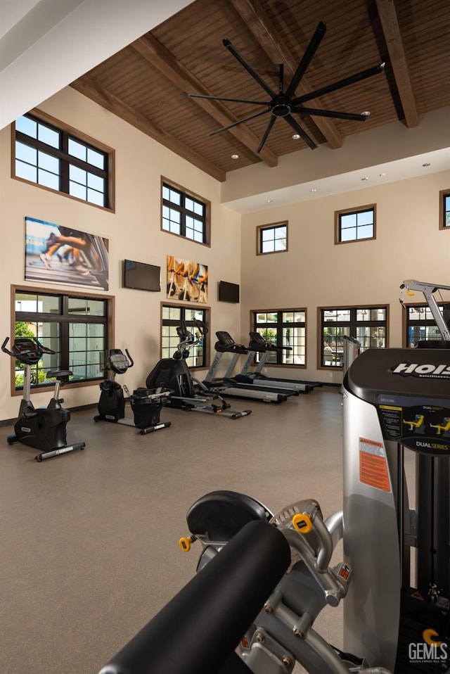 workout area with a high ceiling, wooden ceiling, and ceiling fan