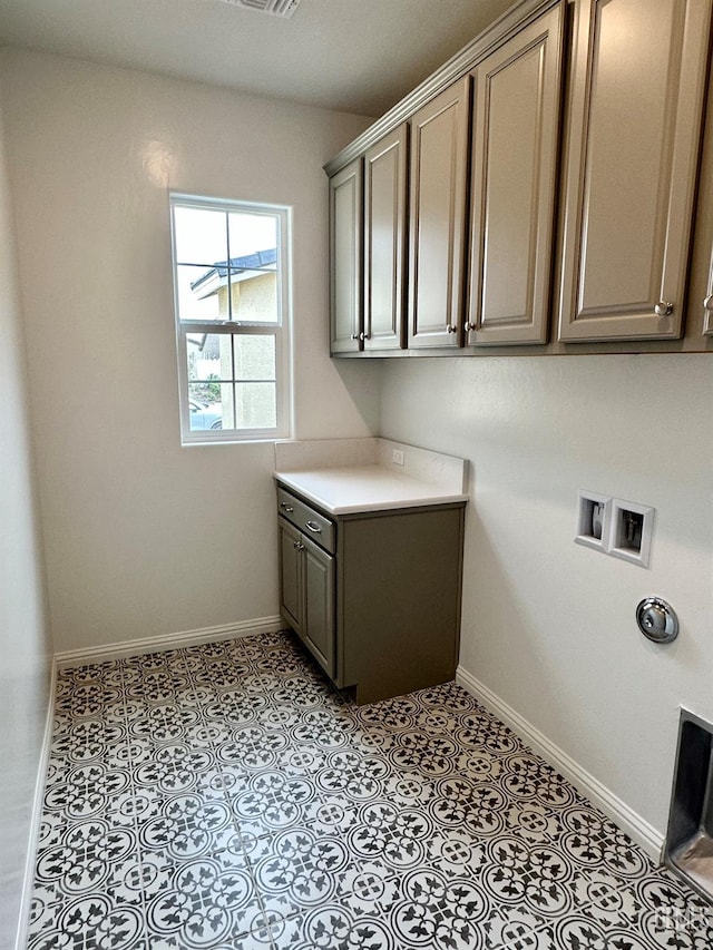 laundry area with washer hookup, light tile patterned floors, and cabinets