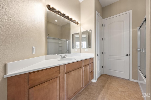 bathroom featuring bath / shower combo with glass door, tile patterned floors, and vanity